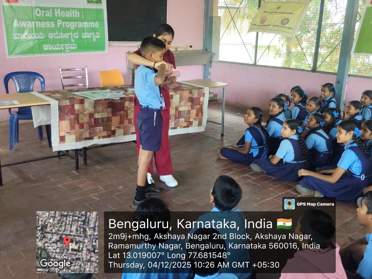 Dentist conducting an oral health awareness session for students